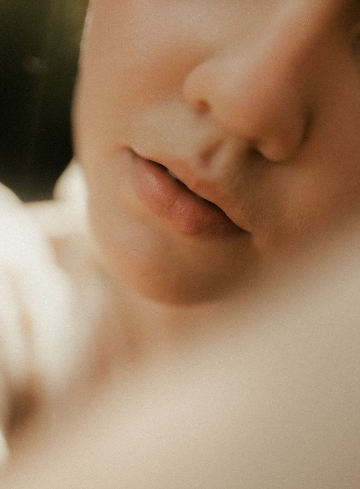 Soft focus close-up of natural lips in warm ivory light